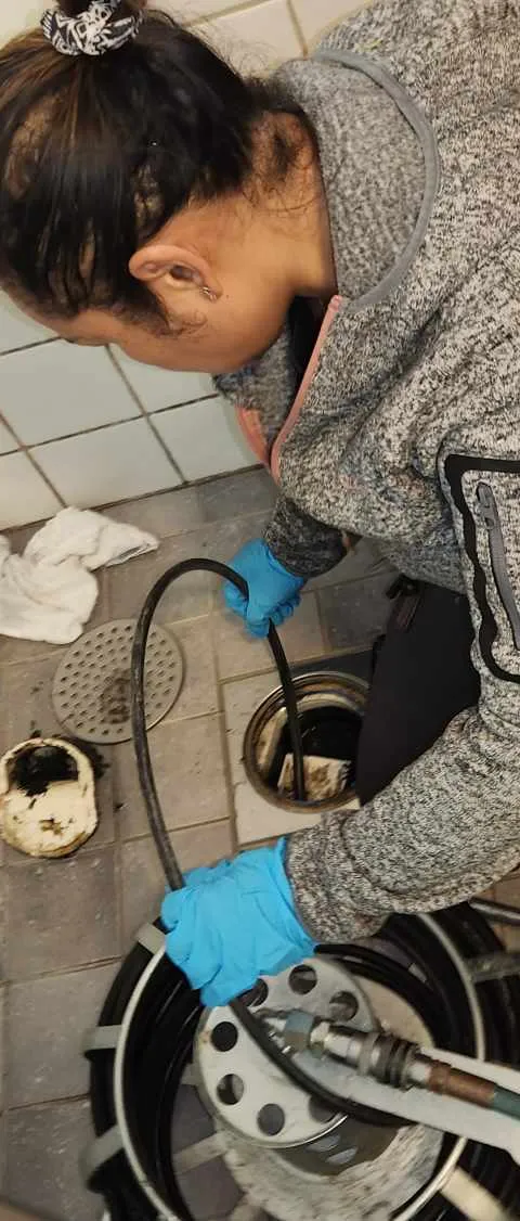 Rörmokare från Allmänna Rörjouren rensar en golvbrunn med rensmaskin
